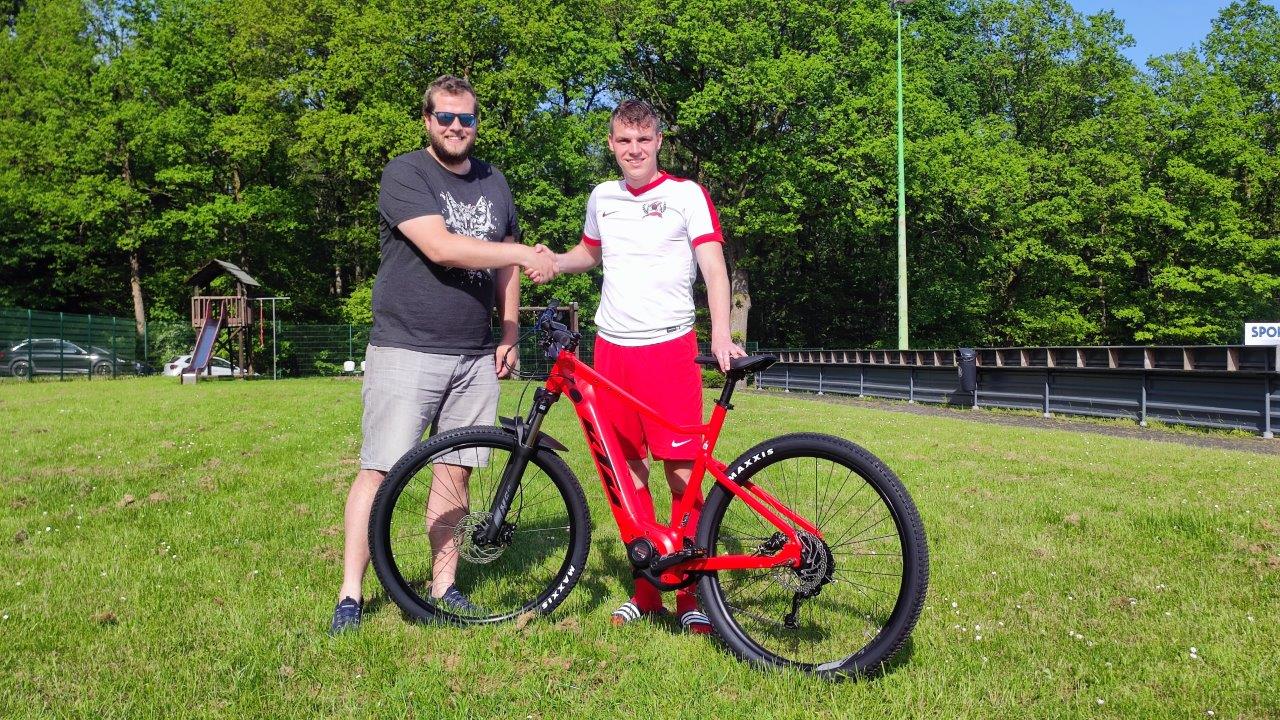 Michael Schrage (rechts im Bild) holte sich den Hauptgewinn der Tombola ab und freut sich über das neue E-Bike von Fahrrad Feldmann